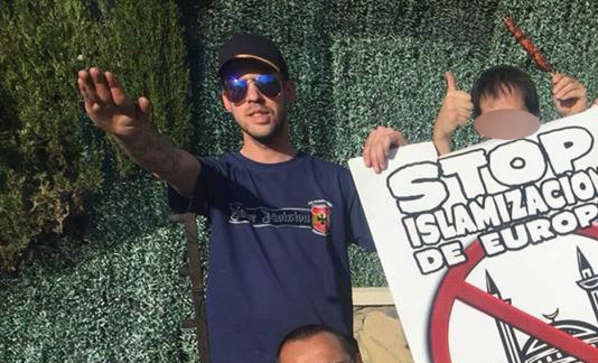 David DG fent la salutació feixista mentre aguanta un cartell anti-islam