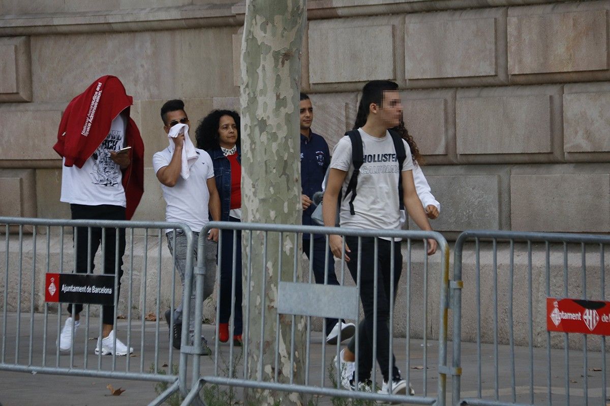 Tres dels acusats, acompanyats d'una familiar, arribant a l'Audiència de Barcelona