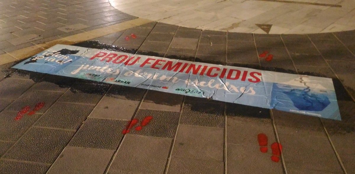 Imatge de la pancarta enganxada al terra de la plaça de Crist Rei