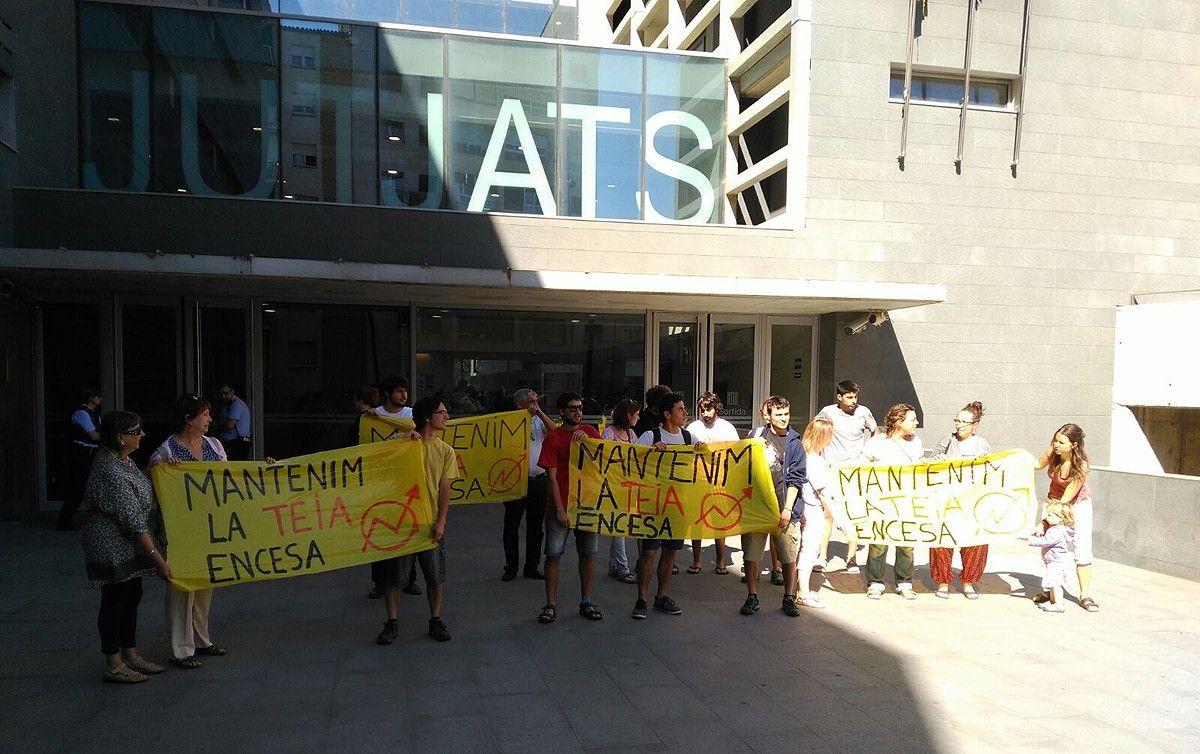 Membres de l'Ateneu Ca La Teia de Santpedor amb pancartes als jutjats de Manresa