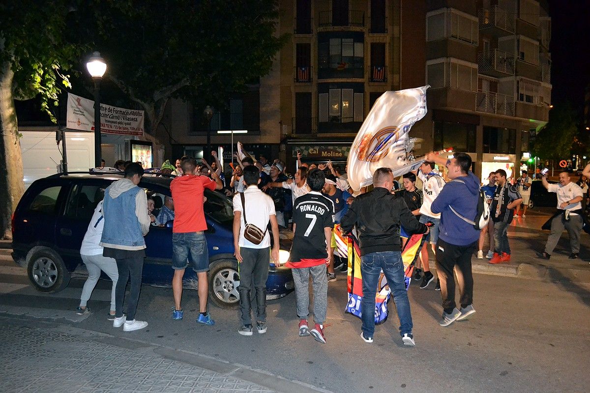 Aficionats del Reial Madrid celebren la Lliga a Crist Rei amb un cotxe que passava