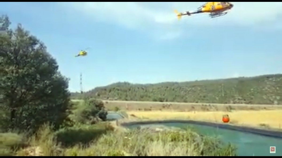 Dos helicòpters abastint-se d'aigua durant l'incendi de Rajadell