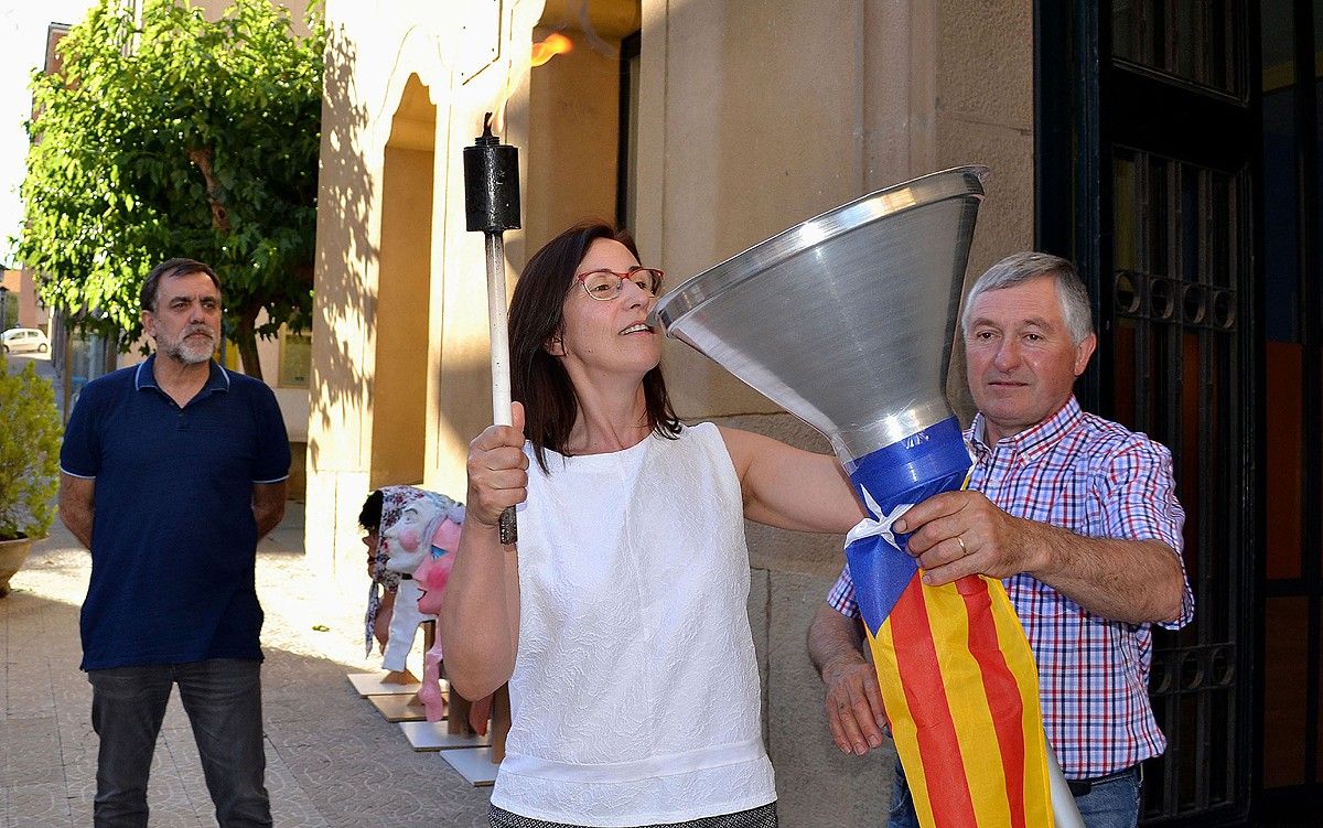 L'alcaldessa accidental, Carme Besa, encén el peveter amb la Flama del Canigó, al costat dels regidors Joan Castellà i Miquel Caelles