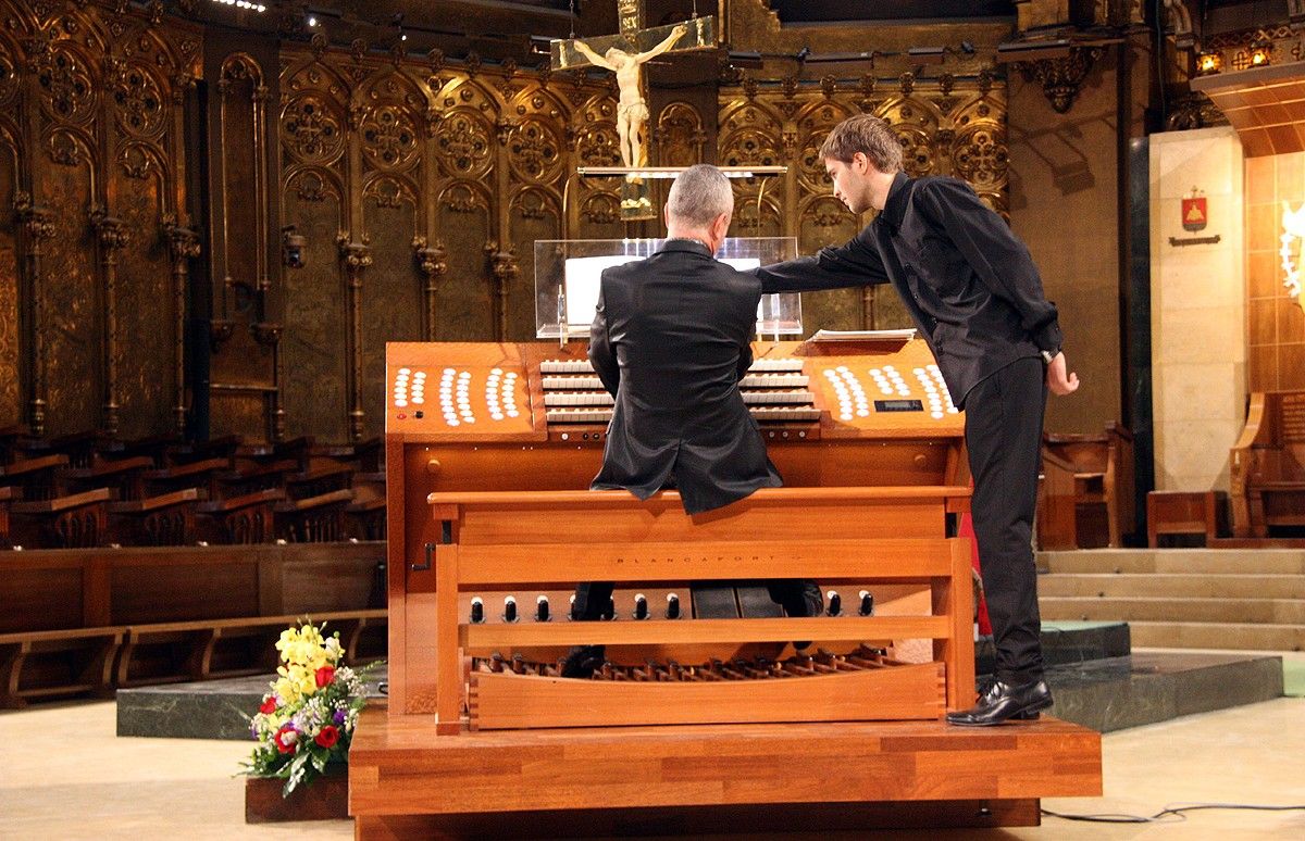 L'organista Olivier Vernet, d'esquenes, tocant la consola de l'orgue de Montserrat en el concert inaugural del Festival