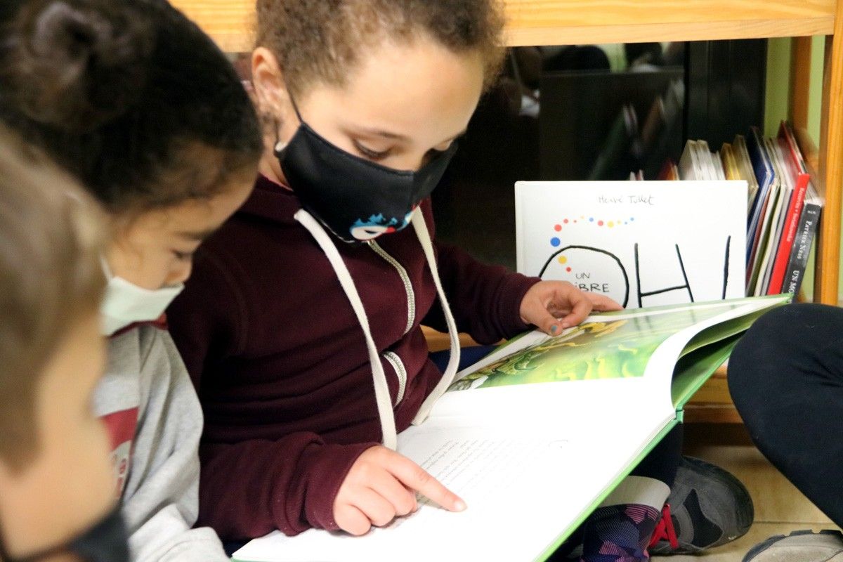 Nenes llegint un llibre a l'Escola Popular de Manresa