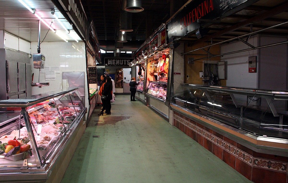 Pla general de l'interior del Mercat Puigmercadal amb algunes botigues obertes i d'altres de tancades