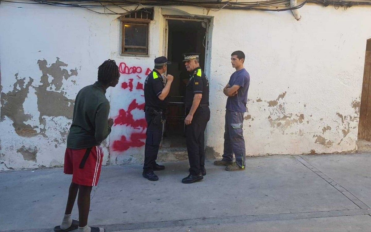 Dos agents de la Policia Local de Manresa davant la porta d'entrada a l'edifici del carrer Aiguader