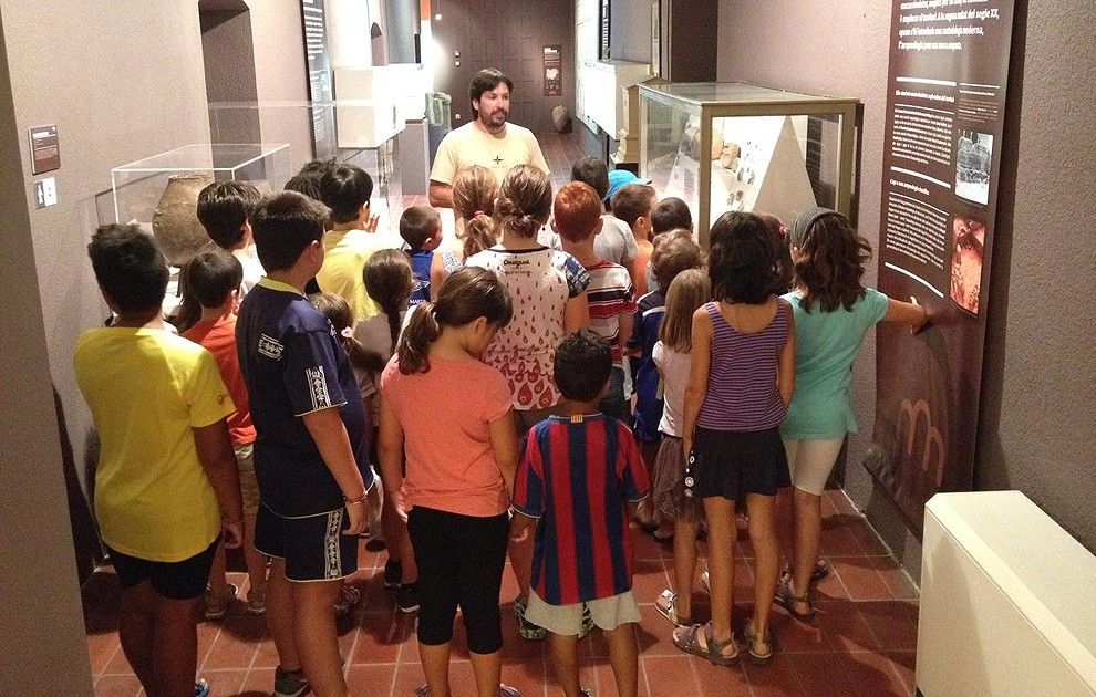 Grup de joves seguint el taller sobre la prehistòria al Museu Comarcal.
