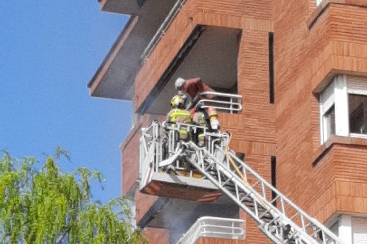 Els bombers en el moment d'accedir al balcó incendiat