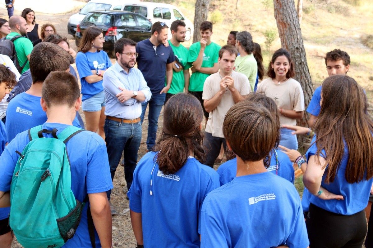 Pere Aragonès escolta les explicacions del grup de joves que participa en un camp de treball d'Artés