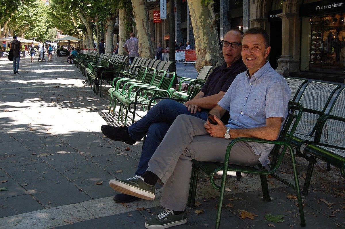 El regidor Joan Calmet, en primer pla, assegut en una de les cadires del Passeig