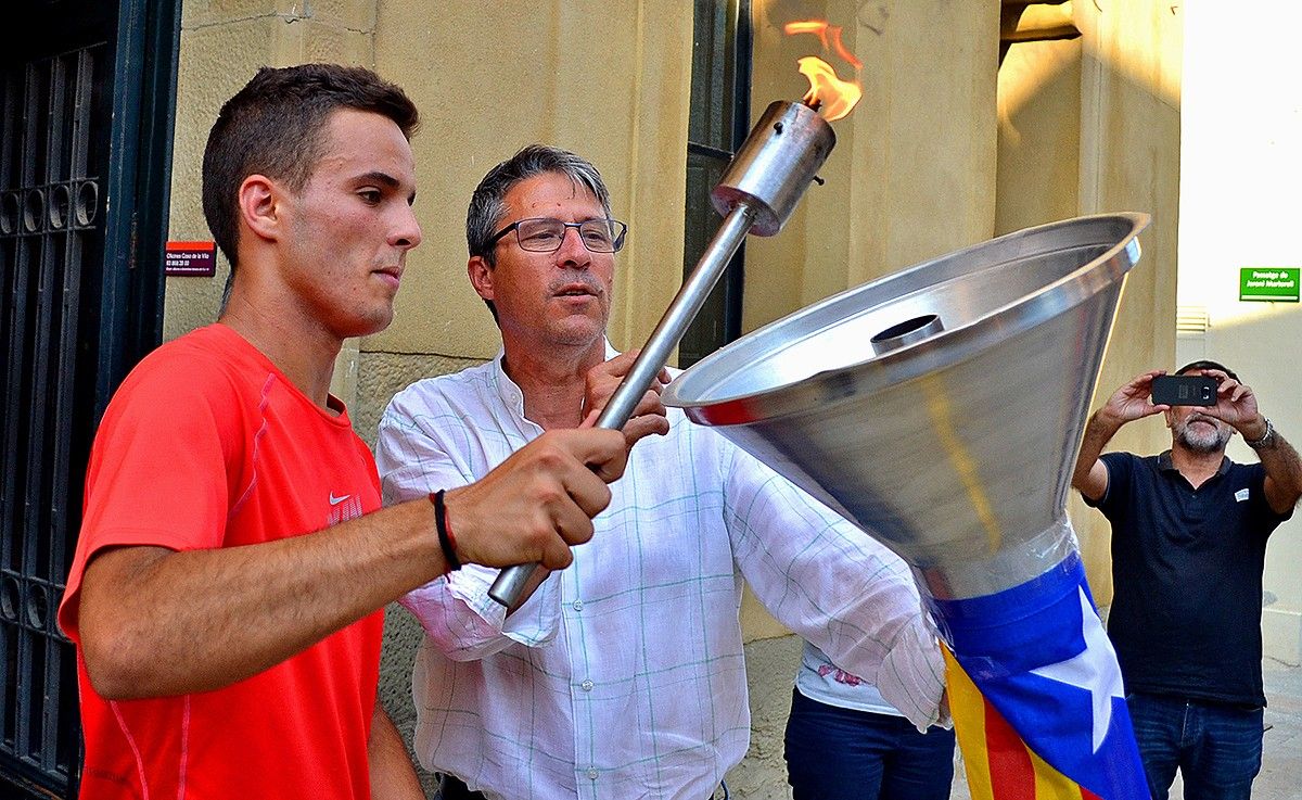 Encesa del peveter de la Flama del Canigó a Súria, amb l'alcalde Josep Maria Canudas i un dels esportistes portadors