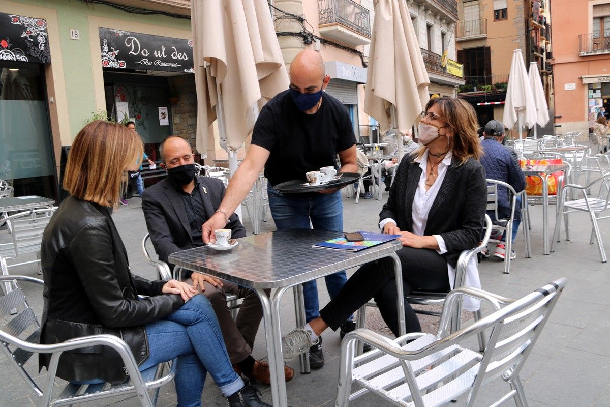 Les regidores Cristina Cruz i Núria Masgrau, amb l'alcalde de Manresa, Marc Aloy, consumint en un bar de la plaça Major