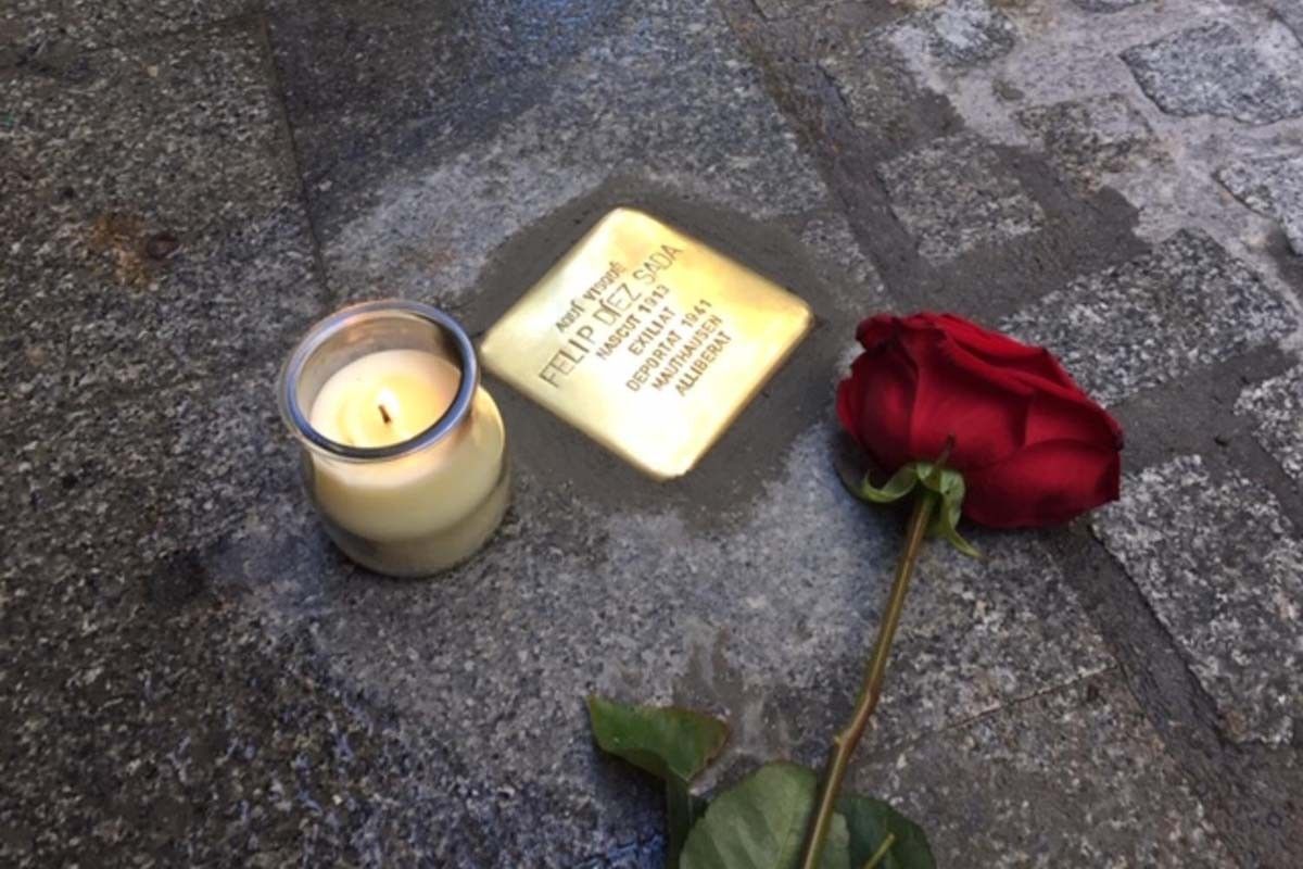 Una rosa i una espelma a la vora d'una rajola stolpersteine
