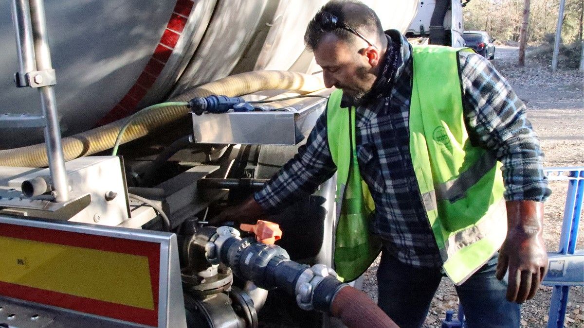 Un operari transvasa l'aigua de la cisterna del camió al dipòsit municipal de Castellcir