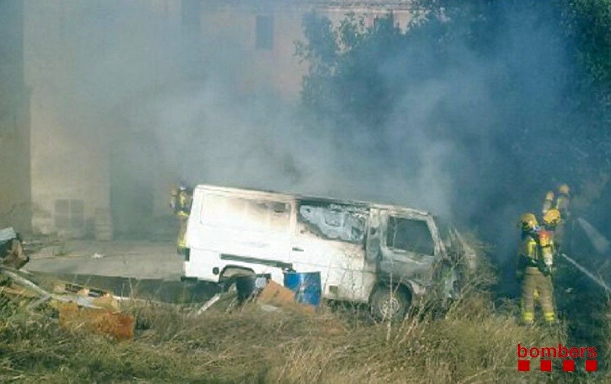 Els Bombers apagant les flames d'una de les furgonetes incendiades