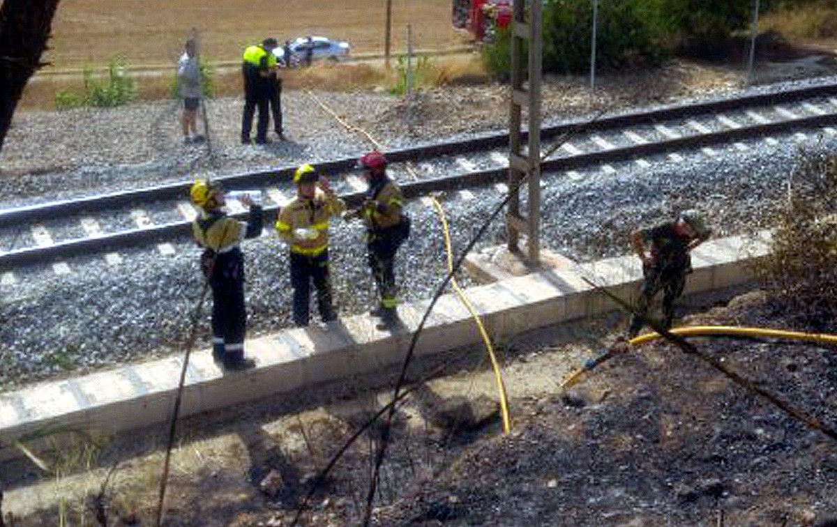 Bombers i tècnics analitzant la línia ferroviària a l'altura de Castellgalí