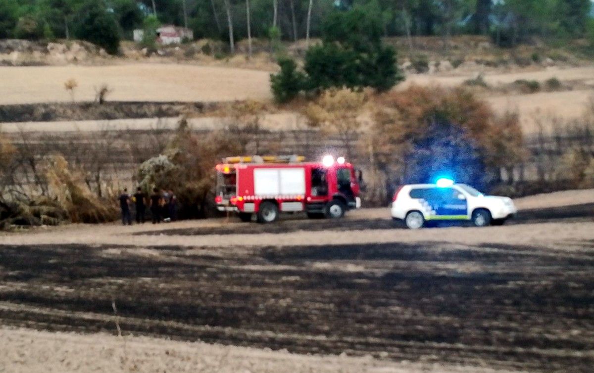 Un vehicle de Bombers i de la Policia Local de Navarcles al lloc cremat