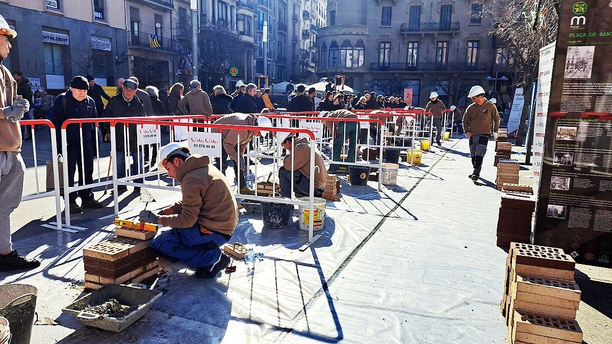 Els concursants construint una columna sota l'atenta mirada dels vianants