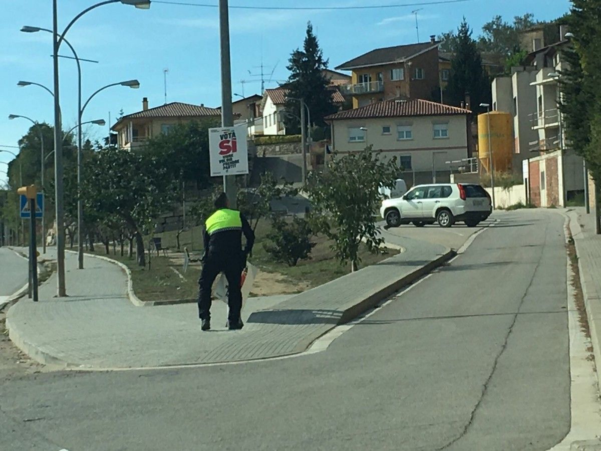 L'agent de la Policia Local de Moià despenjant cartells