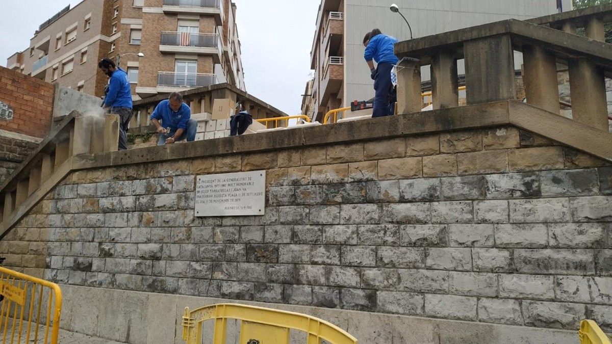 Operaris reparant la barana de la plaça Onze de Setembre