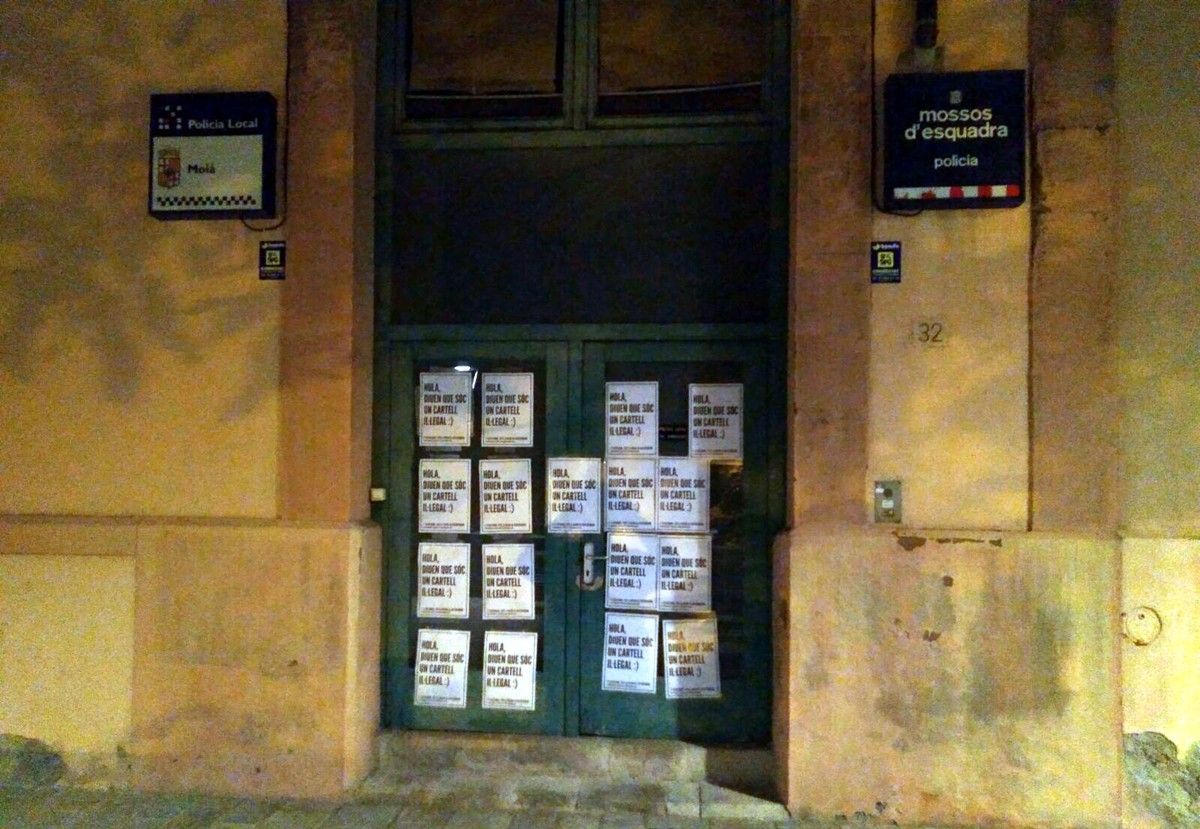 Porta de la Polician Local de Moià amb els cartells enganxats de matinada