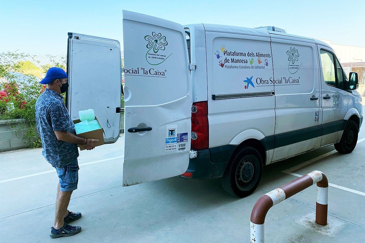 Un voluntari carrega acumuladors de fred en una furgoneta de la Fundació Santa Clara