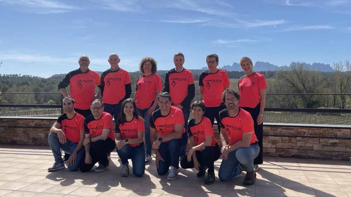 Foto de grup de membres de l'organització de la Marxa del Pelegrí amb la samarreta de la prova