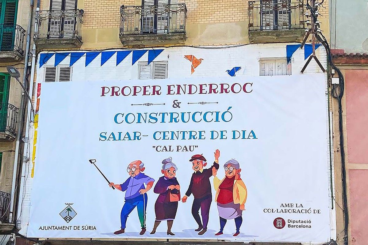 Façana de l’edifici de Cal Pau, amb la pancarta que anuncia l'enderrocament