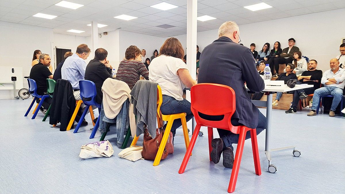 Els set alcaldables asseguts en cadires d'escola responent les preguntes sobre polítiques socials