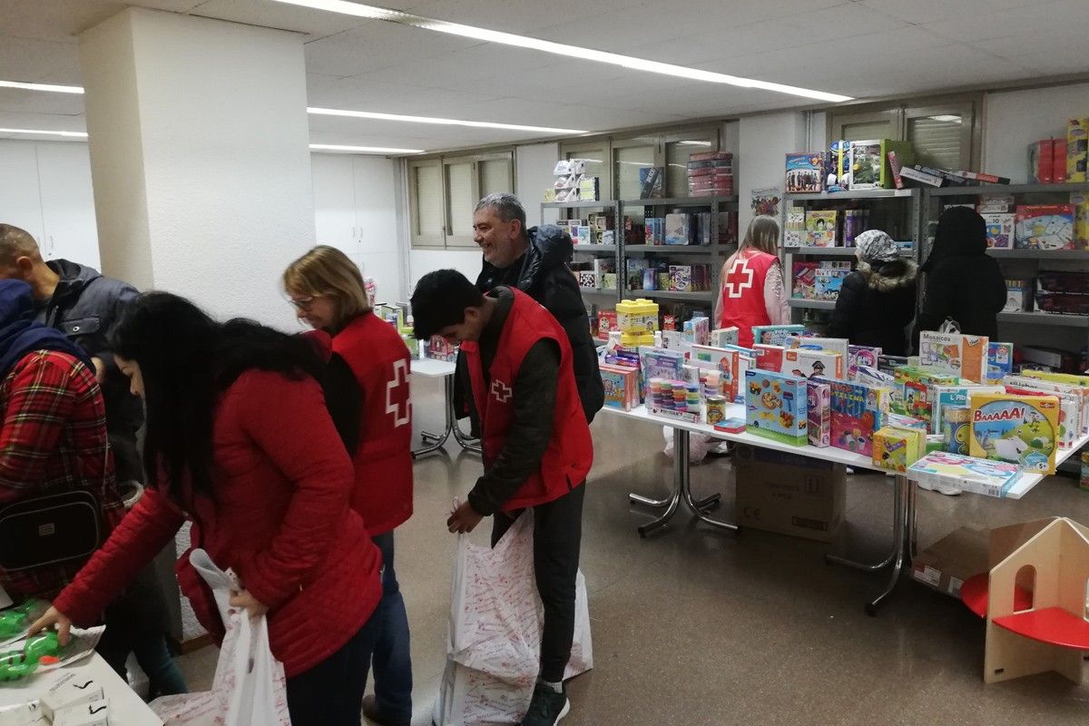 Voluntaris de Creu Roja preparant els regals per lliurar als Reis d'Orient