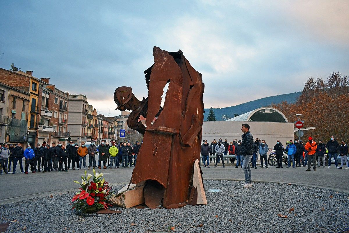 Les persones assistents a l'ofrena floral al monument de la Mineria escolten l'himne de Santa Bàrbara
