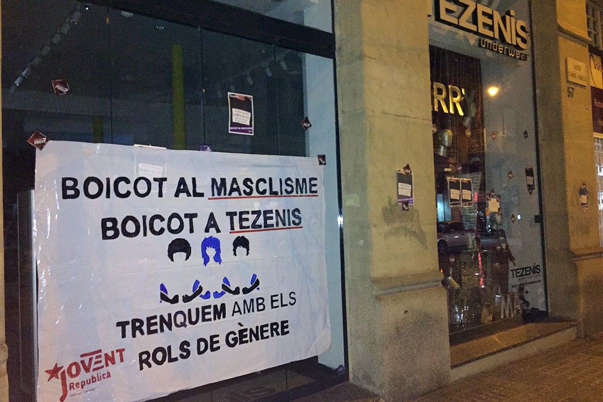 Membres de Jovent Republicà han enganxat una pancarta a l'aparador de Tezenis