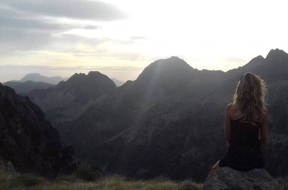Marta Heredia, d'esquena, observant el paisatge muntanyós