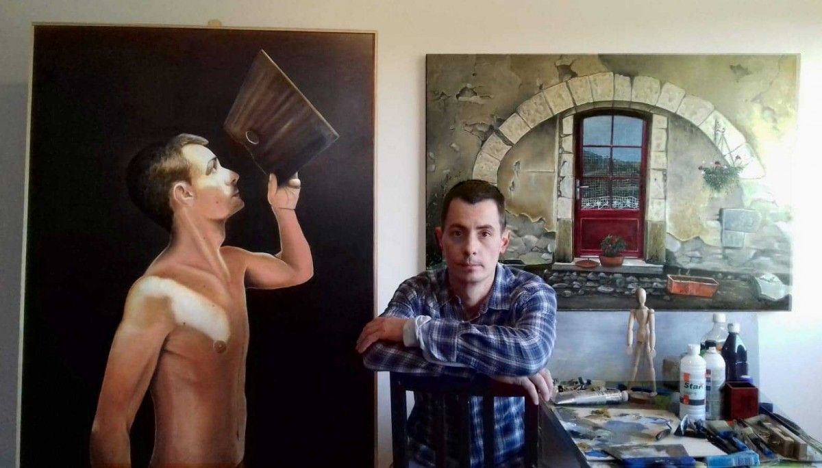 Gerard Martín, al seu estudi, amb dos quadres seus al costat
