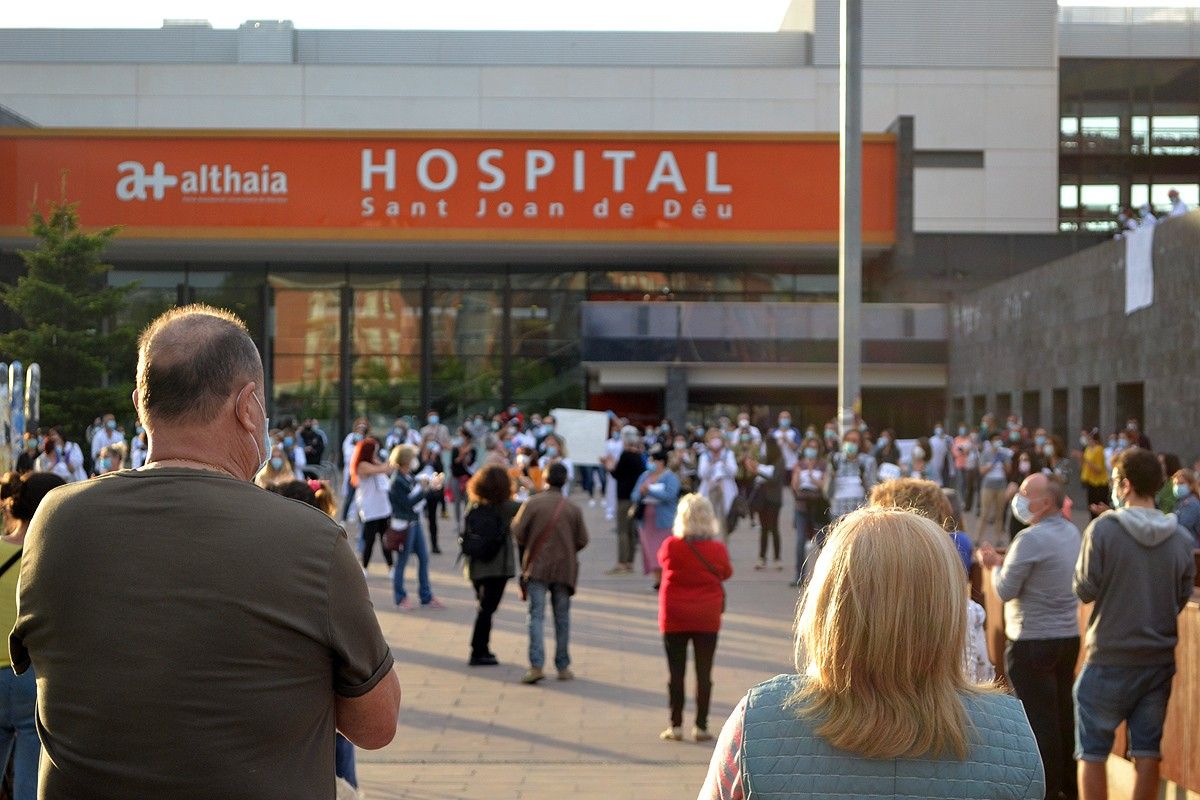Els treballadors a l'entrada de l'hospital amb ciutadans donant-los suport