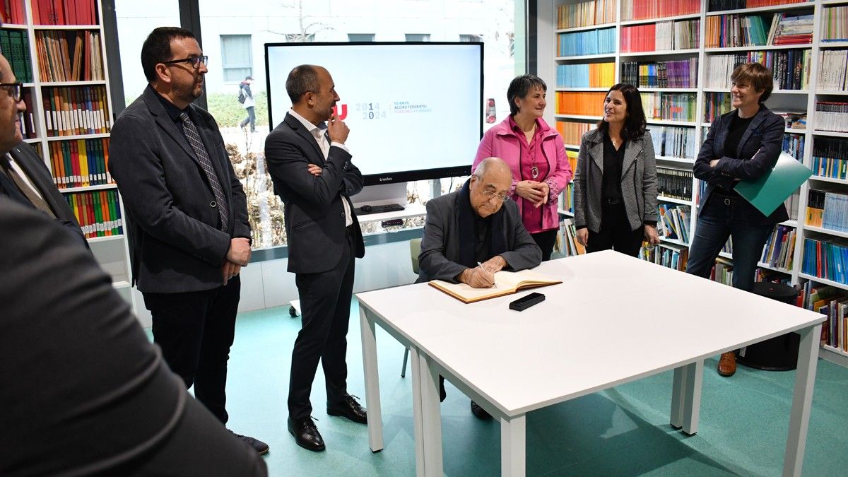 El conseller Joaquim Nadal signant al llibre d'honor de la universitat