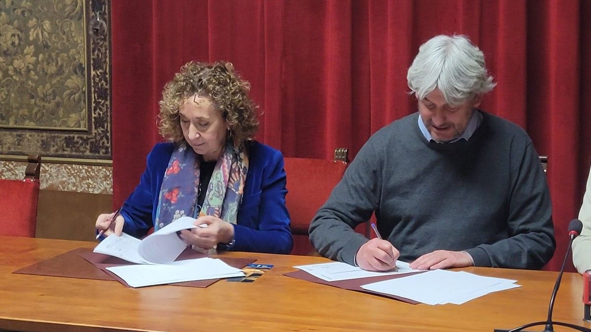 Ester Capella i Dionís Guiteras signant el conveni