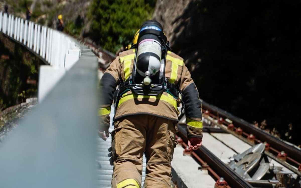 Un bomber, amb tota la seva equipació, fent la Vertical Montserrat