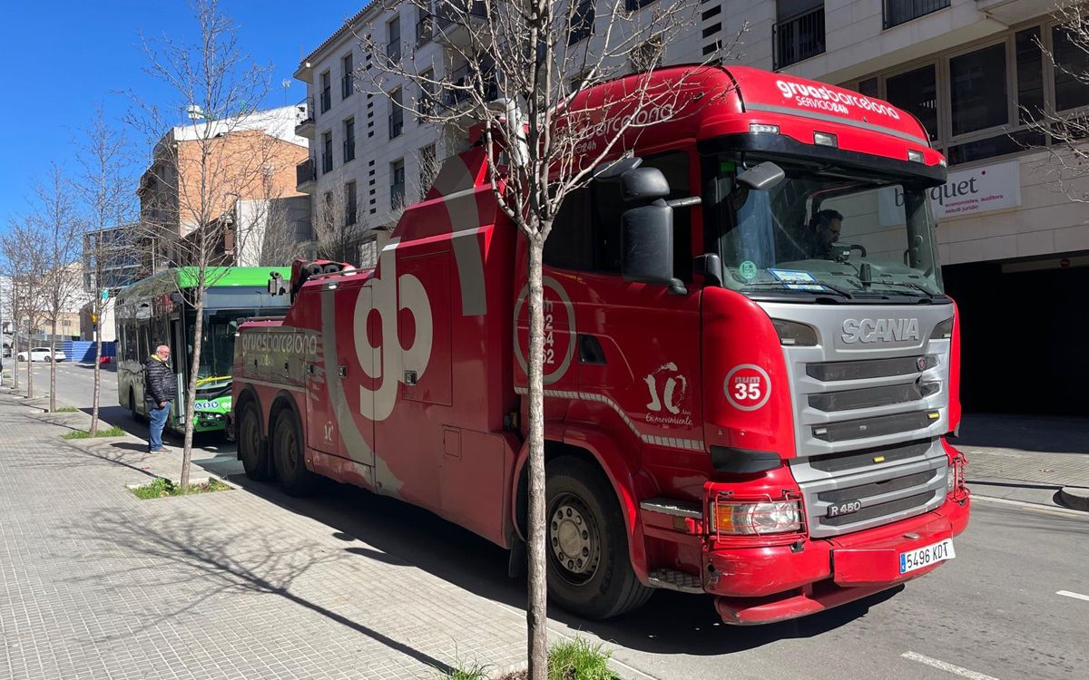 El camió-grua enganxant el bus avariat per a remolcar-lo