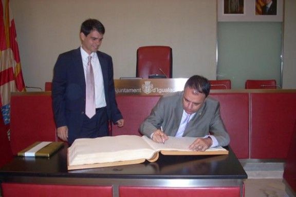 Valentí Junyent signa al llibre d'honor davant l'alcalde d'Igualada, Marc Castells.
