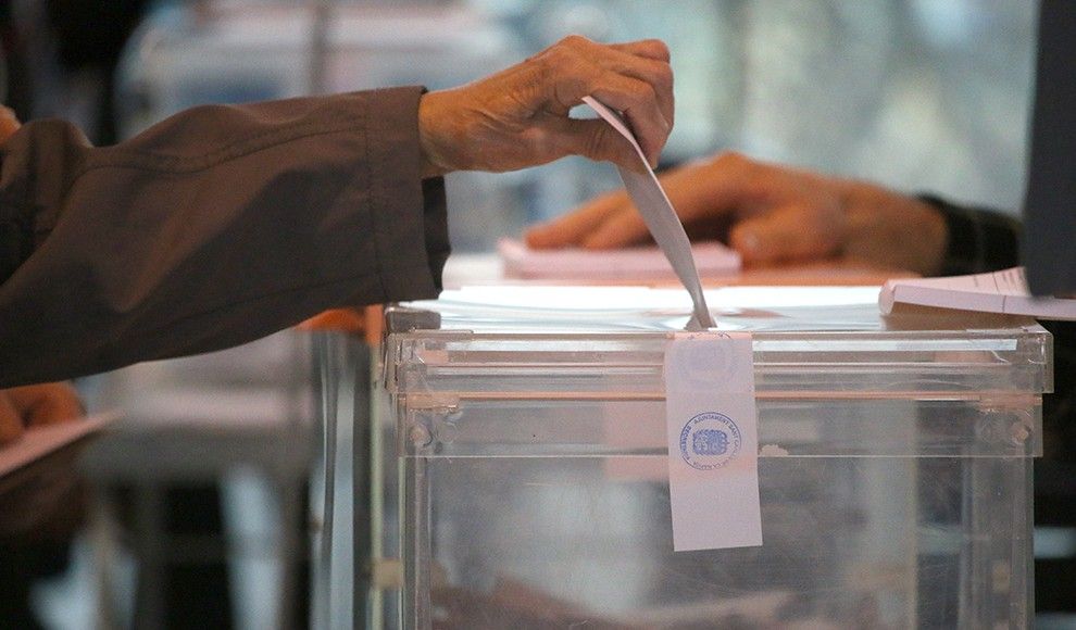 Una persona dipositant el seu vot en una urna.