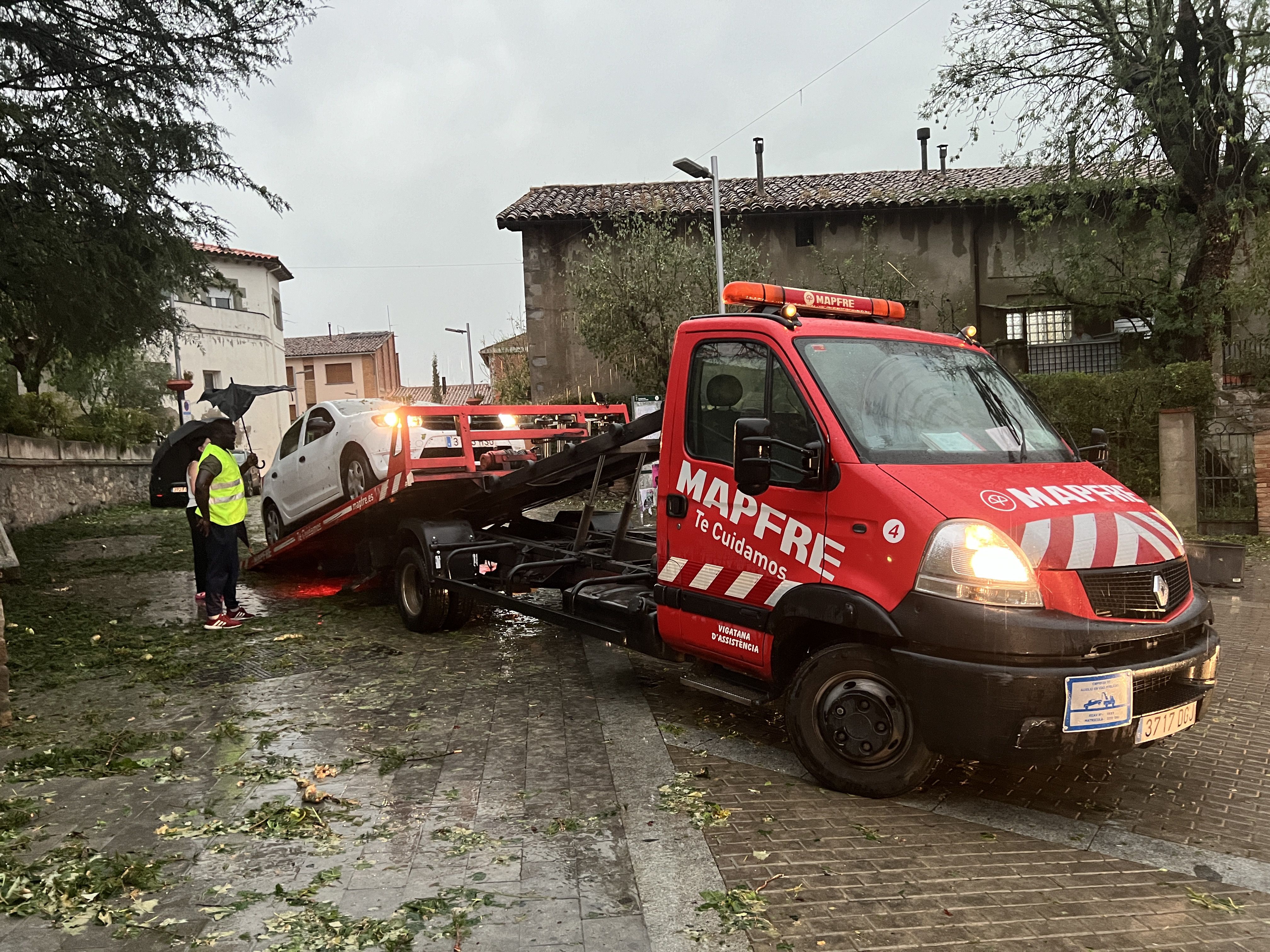 Una grua retira un vehicle afectat per la tempesta