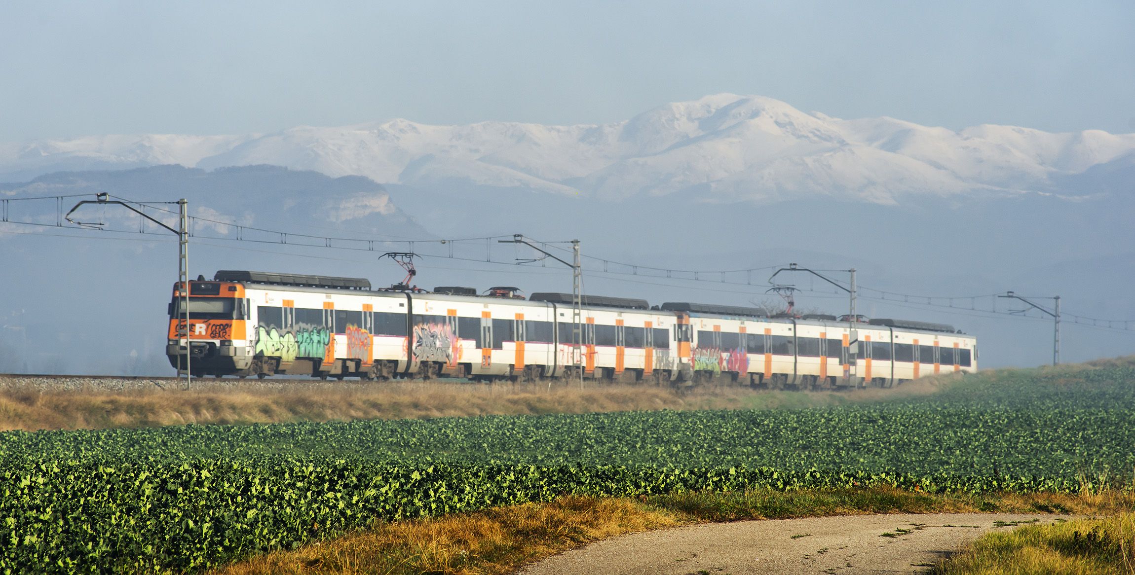 Un tren de l'R3 creuant la boira al seu pas per Malla, Osona.