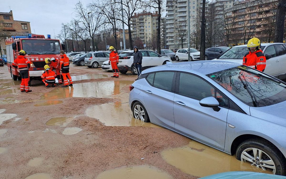 Els Bombers treballant per treure el cotxe atrapat al pàrquing del Sucre de Vic.