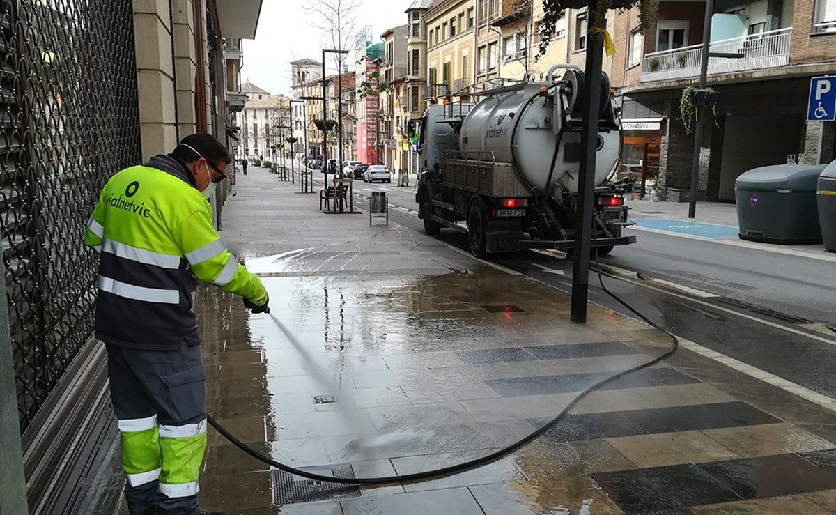 Un operari netejant un carrer de Vic