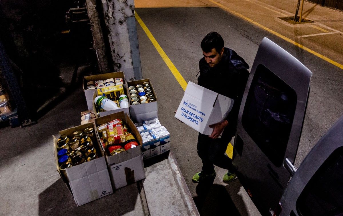 Un voluntari porta els alimenta recollita a El Sarró, el banc d'aliments de Manlleu.