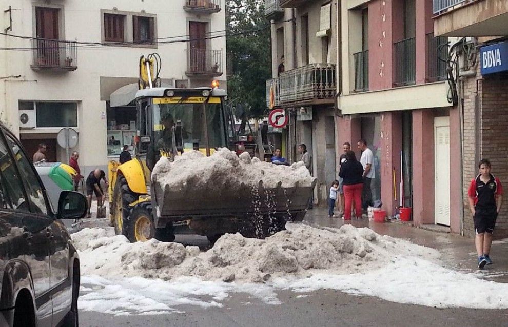Una excavadora retirant la pedra acomulada a la plaça d'en Pujol de Torelló 