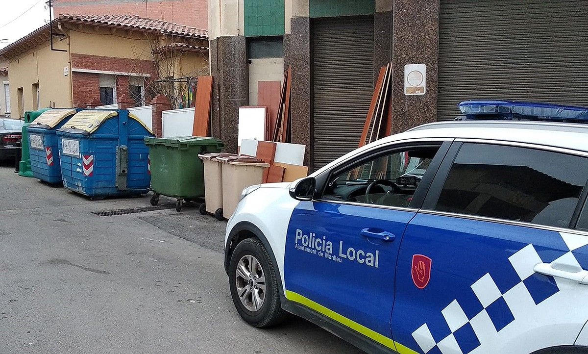 La Policia Local de Manlleu al costat d'uns contenidors