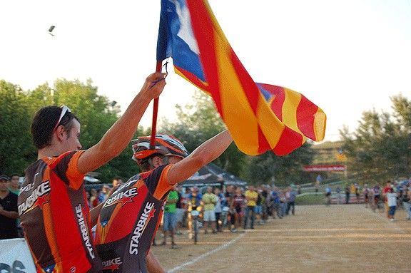 Marià Novella i Gerard Barnolas, de l’equip Starbike, just abans de creuar la meta, amb una bandera estelada.